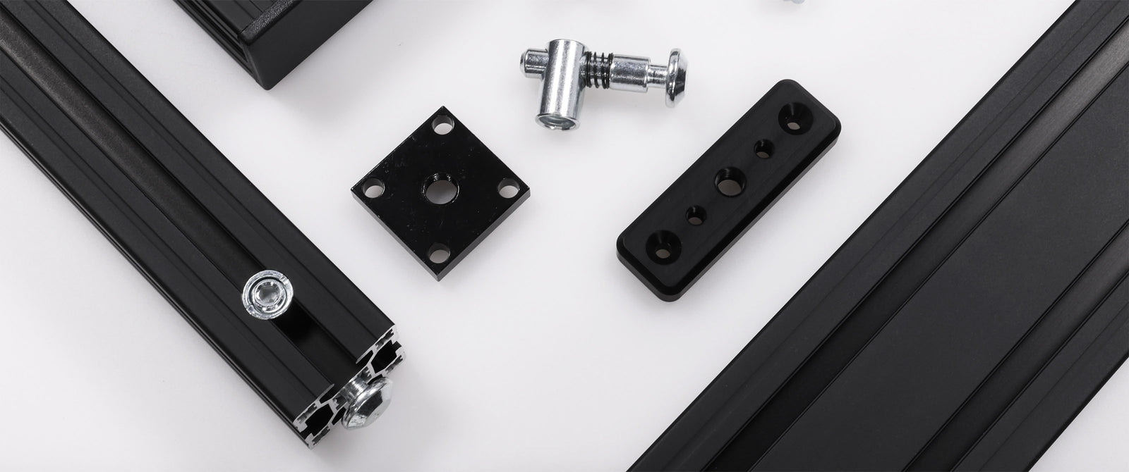 Mechanical components including black metal brackets and cylindrical parts on a white background